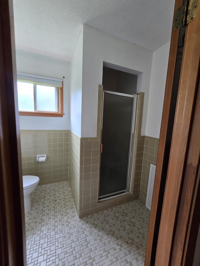 8355 Craven Rd, Bartlett, TN 38002 - full bath featuring tile walls, a stall shower, wainscoting, and a textured ceiling