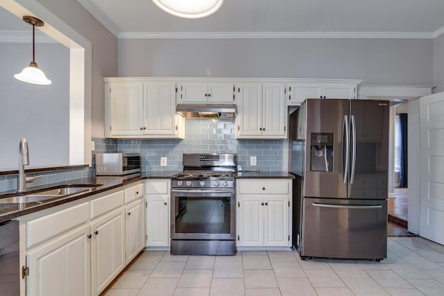 699 New York St, Memphis, TN 38104 - kitchen with appliances with stainless steel finishes, under cabinet range hood, crown molding, decorative backsplash, and light tile patterned flooring