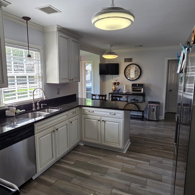 6380 Davidson Cv, Memphis, TN 38119 - kitchen with stainless steel appliances, a peninsula, dark countertops, ornamental molding, and pendant lighting