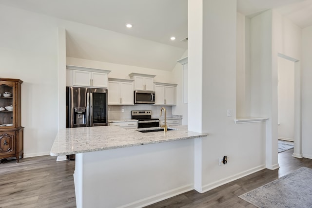 50 Misty Meadow Ln, Oakland, TN 38060 - kitchen featuring stainless steel appliances, wood finished floors, decorative backsplash, light stone counters, and lofted ceiling