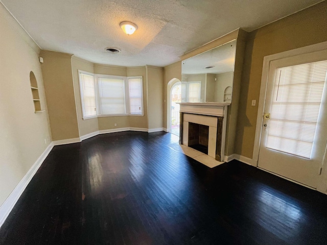 990 N Avalon St, Memphis, TN 38107 - unfurnished living room featuring arched walkways, wood finished floors, a textured ceiling, and a fireplace