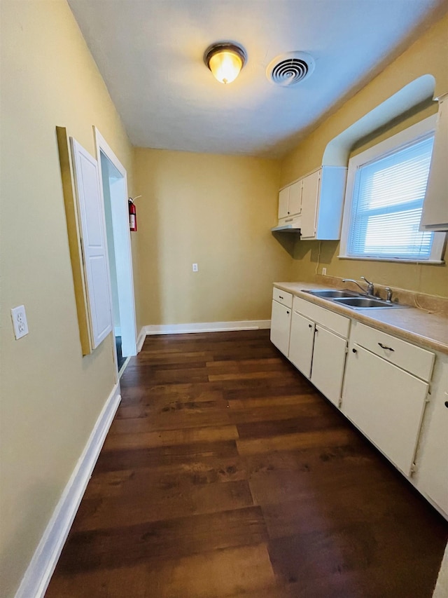 990 N Avalon St, Memphis, TN 38107 - kitchen with white cabinetry, dark wood finished floors, light countertops, and under cabinet range hood