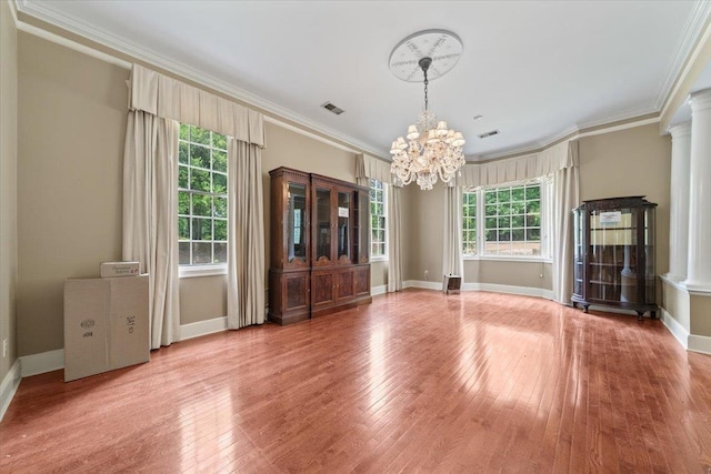 881 S Perkins Rd, Memphis, TN 38117 - unfurnished dining area with a chandelier, plenty of natural light, light wood finished floors, crown molding, and ornate columns