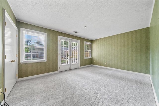 881 S Perkins Rd, Memphis, TN 38117 - carpeted spare room with a textured ceiling, french doors, and wallpapered walls