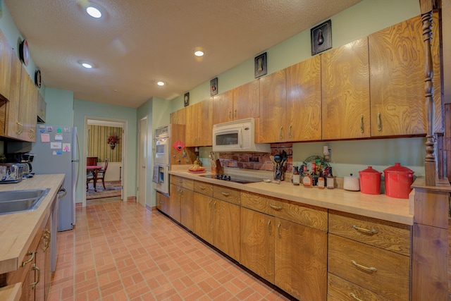 2011 Kirby Pkwy, Memphis, TN 38119 - kitchen featuring light countertops, white appliances, brick patterned floors, recessed lighting, and brown cabinetry