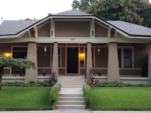 1747 Lawrence Ave, Memphis, TN 38112 - view of front of property featuring covered porch, roof with shingles, a front lawn, and brick siding