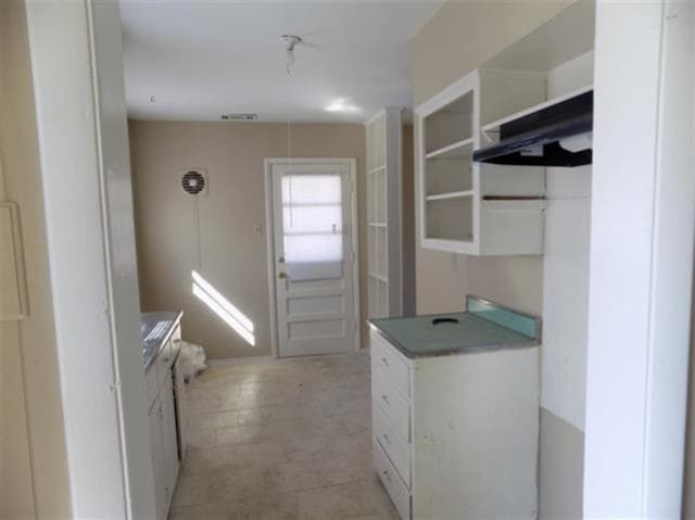 1106 Stratford Rd, Memphis, TN 38122 - kitchen with white cabinetry, under cabinet range hood, and open shelves