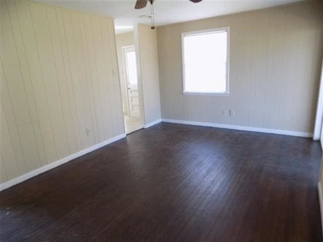 1106 Stratford Rd, Memphis, TN 38122 - unfurnished room with dark wood-type flooring, ceiling fan, and wood walls