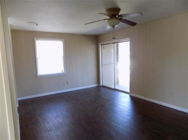 1106 Stratford Rd, Memphis, TN 38122 - spare room with wood finished floors, a ceiling fan, plenty of natural light, and wood walls