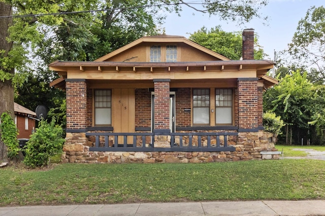 515 N Dunlap St, Memphis, TN 38105 - view of front of property with a porch, a chimney, a front yard, and brick siding