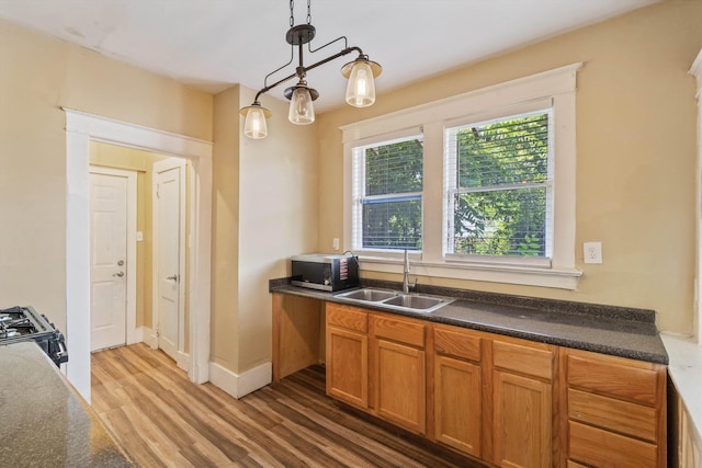 515 N Dunlap St, Memphis, TN 38105 - kitchen featuring light wood-style flooring, stainless steel microwave, dark countertops, decorative light fixtures, and black range with gas cooktop