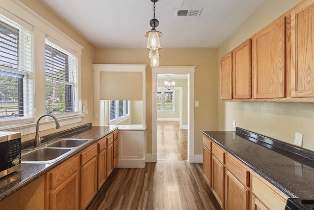 515 N Dunlap St, Memphis, TN 38105 - kitchen with dark wood-type flooring, stainless steel microwave, decorative light fixtures, a chandelier, and dark stone countertops