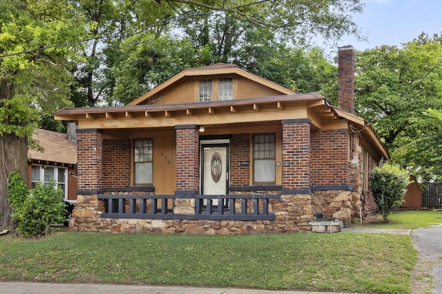 515 N Dunlap St, Memphis, TN 38105 - view of front of property featuring covered porch, a chimney, a front lawn, and brick siding