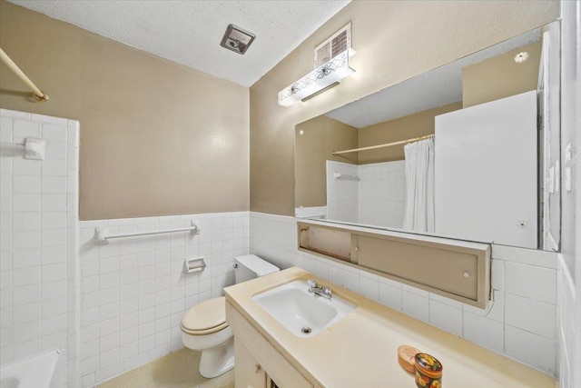 875 S Yates Rd Unit 4, Memphis, TN 38120 - full bathroom featuring tile walls, vanity, wainscoting, a textured ceiling, and shower / bath combination with curtain