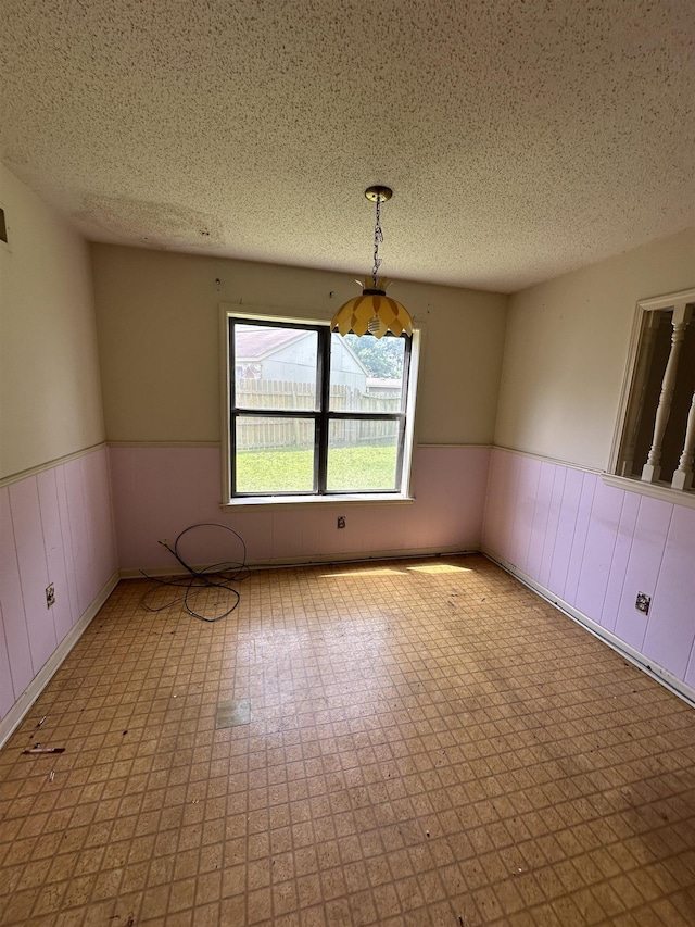 4607 Blue Willow Rd, Memphis, TN 38141 - spare room with wainscoting, a textured ceiling, and tile patterned floors