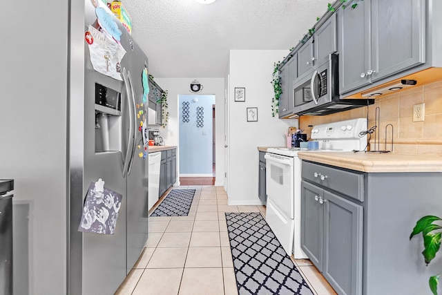 10215 N Green Moss Dr, Cordova, TN 38018 - kitchen featuring appliances with stainless steel finishes, gray cabinetry, light tile patterned flooring, a textured ceiling, and backsplash