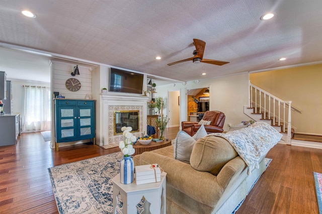 8986 Stratfield Cv, Germantown, TN 38139 - living area featuring wood finished floors, a glass covered fireplace, a ceiling fan, stairway, and crown molding