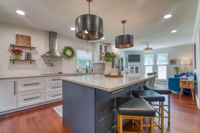 8986 Stratfield Cv, Germantown, TN 38139 - kitchen with wall chimney exhaust hood, white cabinetry, a kitchen breakfast bar, light countertops, and tasteful backsplash