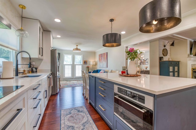 8986 Stratfield Cv, Germantown, TN 38139 - kitchen featuring crown molding, white cabinetry, light countertops, dark wood finished floors, and appliances with stainless steel finishes