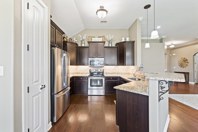 70 Shady Pine Cv, Oakland, TN 38060 - kitchen with stainless steel appliances, a peninsula, dark brown cabinetry, tasteful backsplash, and light stone countertops
