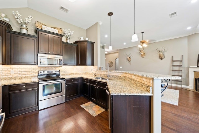 70 Shady Pine Cv, Oakland, TN 38060 - kitchen with stainless steel appliances, tasteful backsplash, dark brown cabinets, light stone counters, and a peninsula