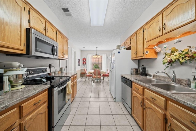 6445 Baird Ln, Bartlett, TN 38135 - kitchen featuring appliances with stainless steel finishes, a textured ceiling, light tile patterned floors, a chandelier, and decorative light fixtures