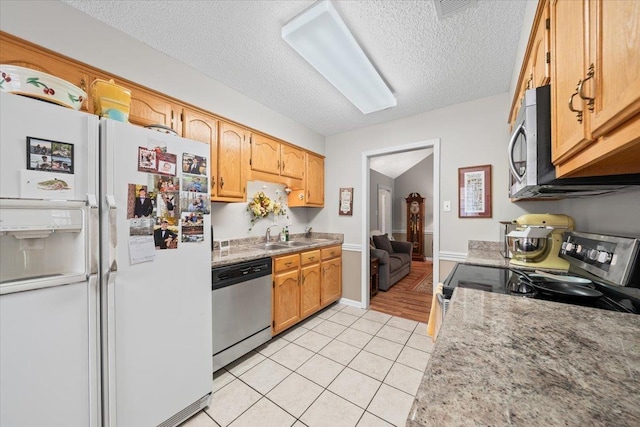 6445 Baird Ln, Bartlett, TN 38135 - kitchen with appliances with stainless steel finishes, light tile patterned floors, a textured ceiling, and light countertops