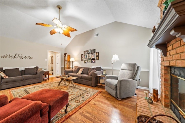 6445 Baird Ln, Bartlett, TN 38135 - living area with lofted ceiling, ceiling fan, wood finished floors, and a brick fireplace