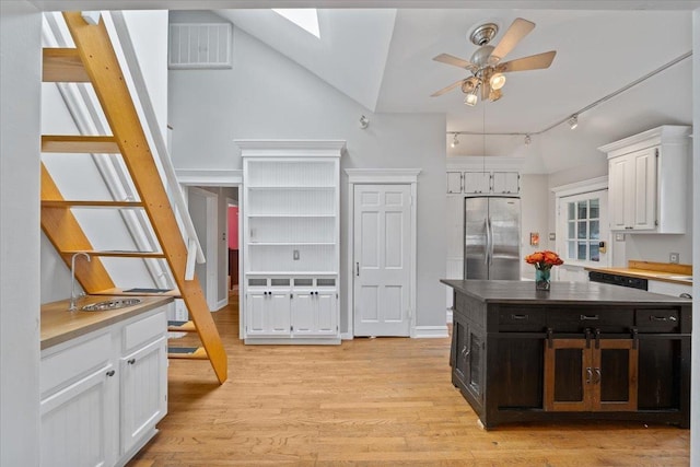 1978 Tutwiler Ave, Memphis, TN 38107 - kitchen featuring stainless steel fridge, white cabinetry, a ceiling fan, a skylight, and light wood finished floors