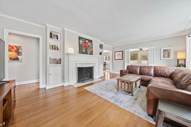 1978 Tutwiler Ave, Memphis, TN 38107 - living area featuring light wood finished floors, crown molding, a high end fireplace, built in features, and a ceiling fan