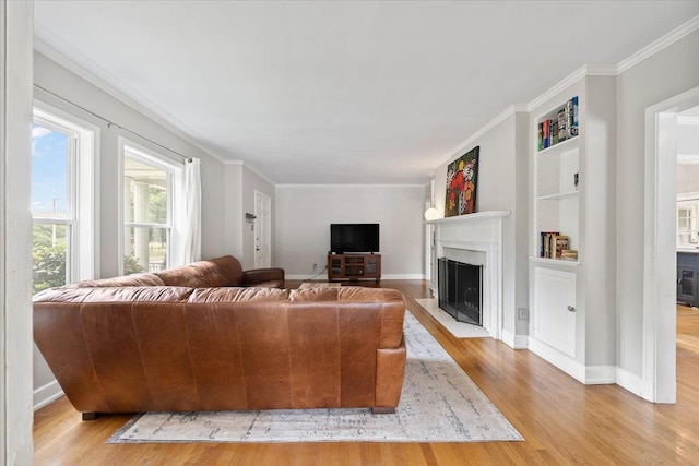 1978 Tutwiler Ave, Memphis, TN 38107 - living room with a fireplace with flush hearth, light wood-type flooring, built in shelves, and ornamental molding