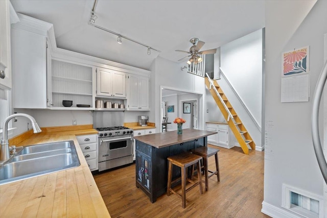 1978 Tutwiler Ave, Memphis, TN 38107 - kitchen featuring stainless steel range, open shelves, rail lighting, a ceiling fan, and butcher block countertops