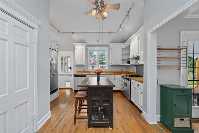 1978 Tutwiler Ave, Memphis, TN 38107 - kitchen featuring stainless steel appliances, track lighting, open shelves, and white cabinetry