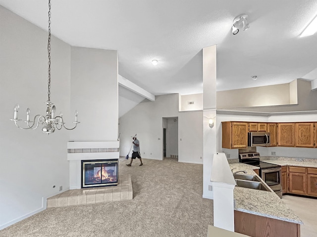 8160 Oak Moss Cv, Memphis, TN 38018 - kitchen with stainless steel appliances, open floor plan, light carpet, and brown cabinets