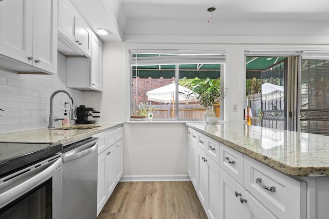 5841 Park Ave Unit 2, Memphis, TN 38119 - kitchen with appliances with stainless steel finishes, tasteful backsplash, light wood-style flooring, and white cabinetry