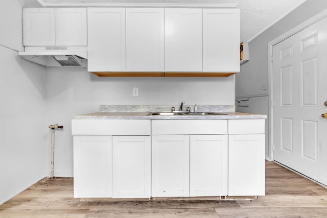 849 Restbrook Ave, Memphis, TN 38127 - kitchen with custom range hood, white cabinetry, light wood-style flooring, and light countertops