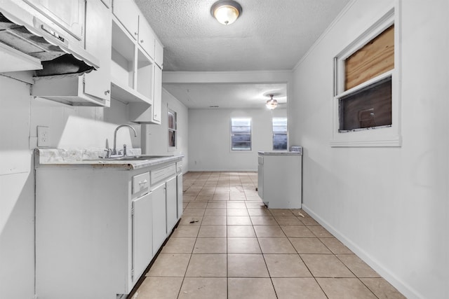 3594 Sunrise St, Memphis, TN 38127 - kitchen with light countertops, a textured ceiling, range hood, white cabinets, and light tile patterned floors