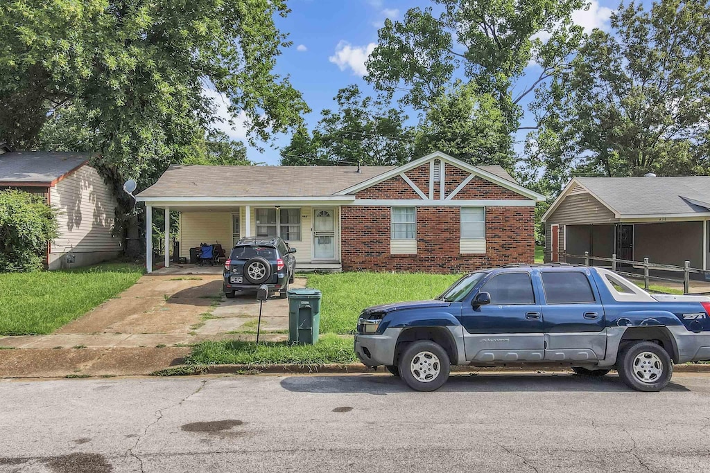 644 Burdette Ave, Memphis, TN 38127 - view of front facade featuring concrete driveway, an attached carport, a front lawn, and brick siding