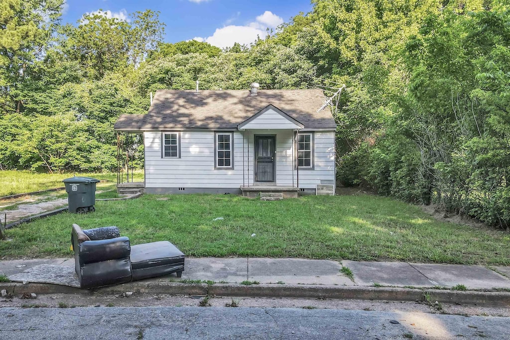 3021 Sunrise St, Memphis, TN 38127 - view of front facade with a front yard and a wooded view