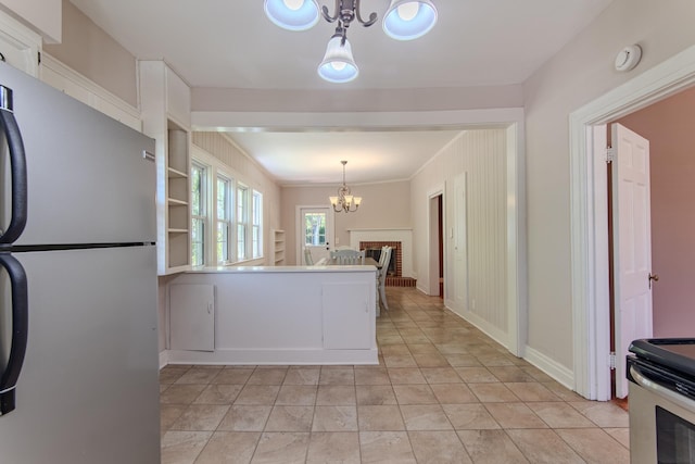 117 N High St, Waynesboro, TN 38485 - kitchen with freestanding refrigerator, a chandelier, pendant lighting, and white cabinets