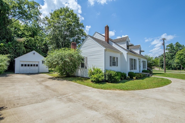 117 N High St, Waynesboro, TN 38485 - view of side of property with an outbuilding, a chimney, a detached garage, a lawn, and concrete driveway