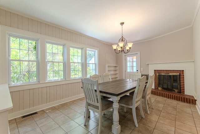 117 N High St, Waynesboro, TN 38485 - dining space featuring ornamental molding, a chandelier, light tile patterned floors, and a brick fireplace