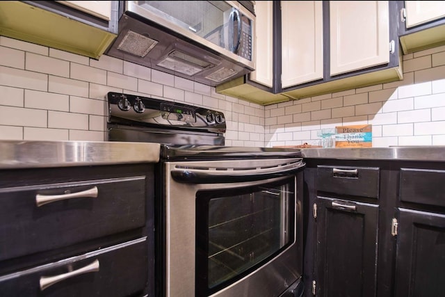 109 N Main St Unit 603, Memphis, TN 38103 - kitchen featuring stainless steel appliances, tasteful backsplash, and white cabinetry