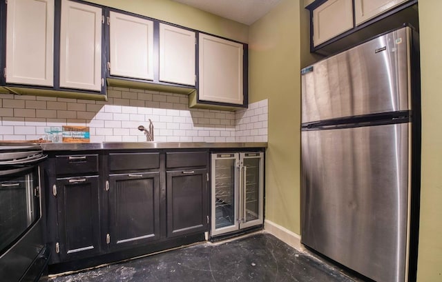 109 N Main St Unit 603, Memphis, TN 38103 - kitchen featuring freestanding refrigerator, beverage cooler, electric range oven, decorative backsplash, and dark countertops