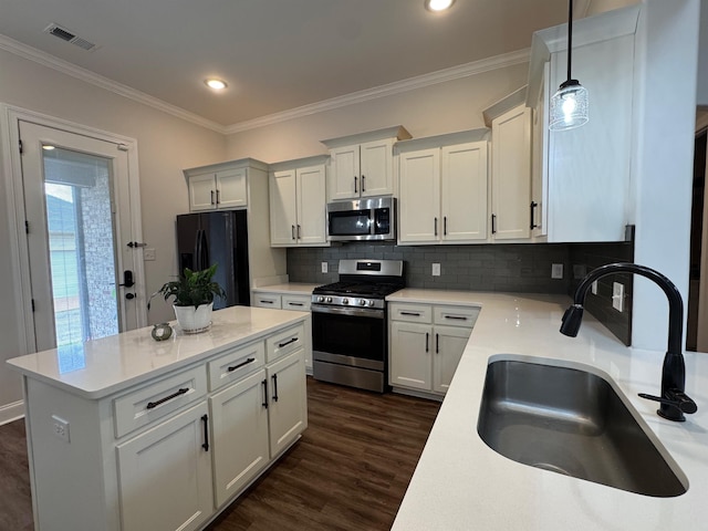 7412 Lost Trail Dr, Cordova, TN 38016 - kitchen with stainless steel appliances, decorative backsplash, a kitchen island, ornamental molding, and decorative light fixtures