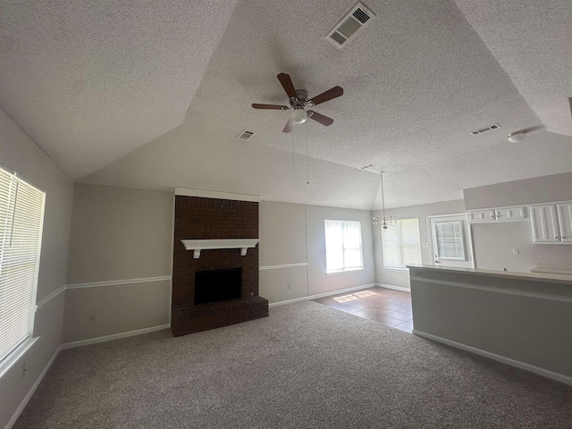 7029 Petten Cv, Memphis, TN 38133 - unfurnished living room with a textured ceiling, carpet flooring, ceiling fan, a fireplace, and a chandelier