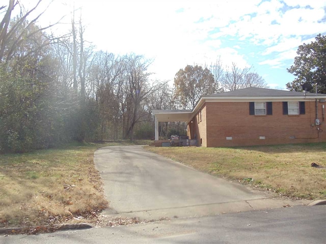 273 Main St, Ripley, TN 38063 - view of side of property featuring crawl space, driveway, brick siding, and a lawn