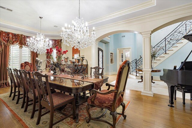 269 N Monterey Farms Cv, Collierville, TN 38017 - dining area featuring arched walkways, a tray ceiling, light wood-style floors, ornamental molding, and a chandelier