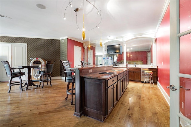 269 N Monterey Farms Cv, Collierville, TN 38017 - kitchen featuring a kitchen breakfast bar, ornamental molding, light wood finished floors, a center island, and open floor plan