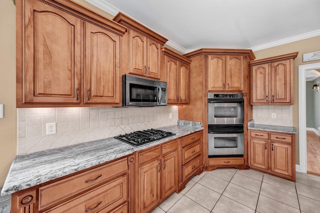 1062 Center Ridge Rd, Collierville, TN 38017 - kitchen featuring appliances with stainless steel finishes, brown cabinetry, decorative backsplash, light tile patterned floors, and crown molding